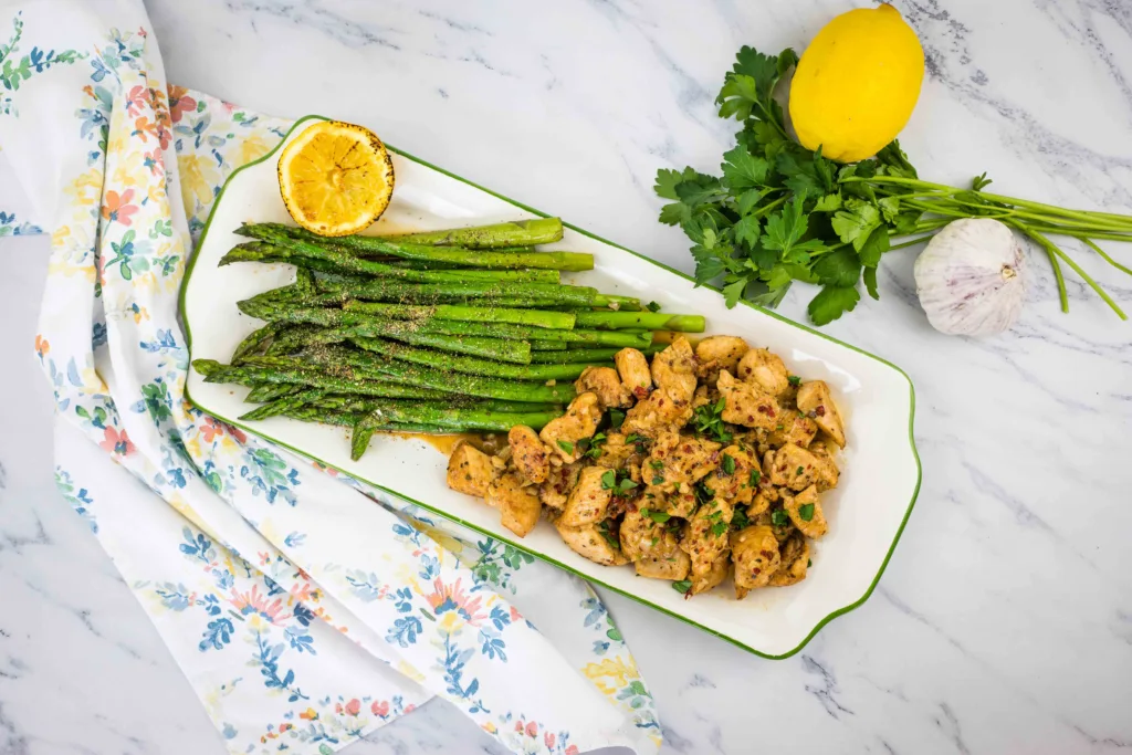 Chicken and asparagus on a plate with lemon.