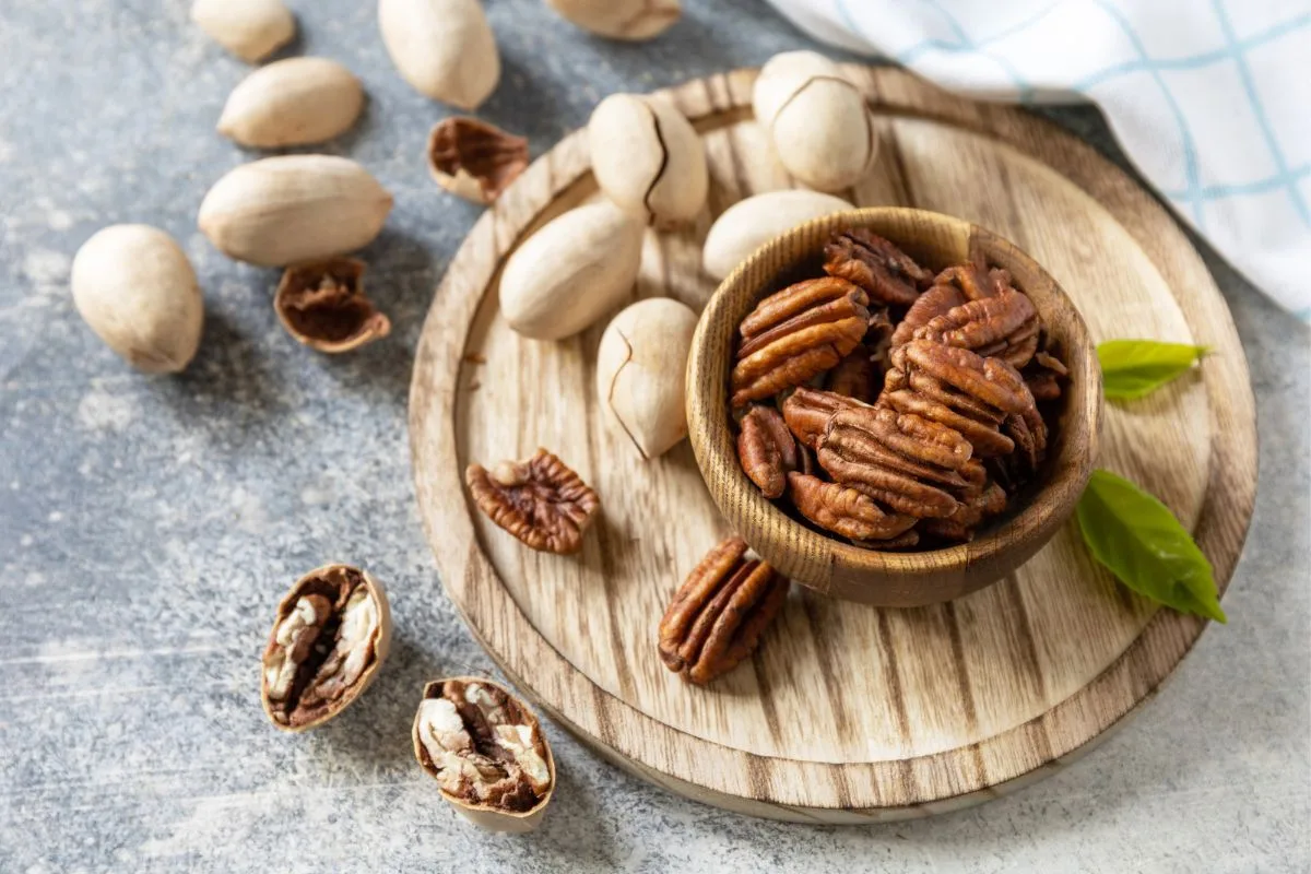 Bowl with pecan nuts on a stone table.