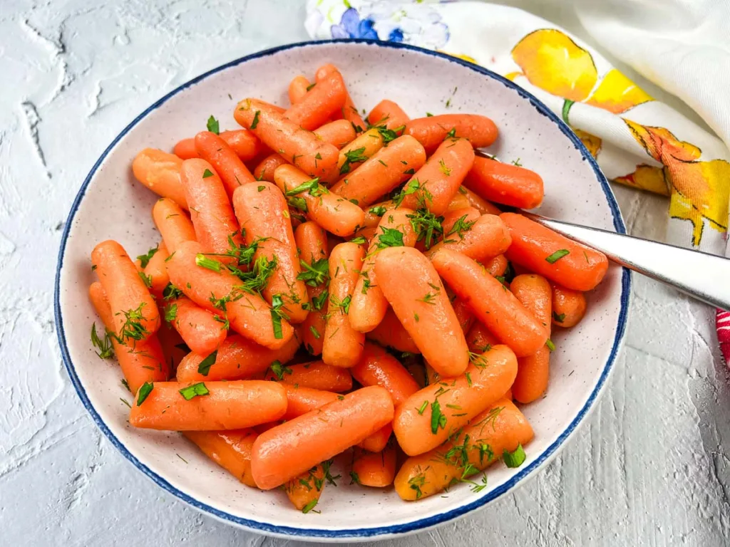 Baby carrots in a white bowl.