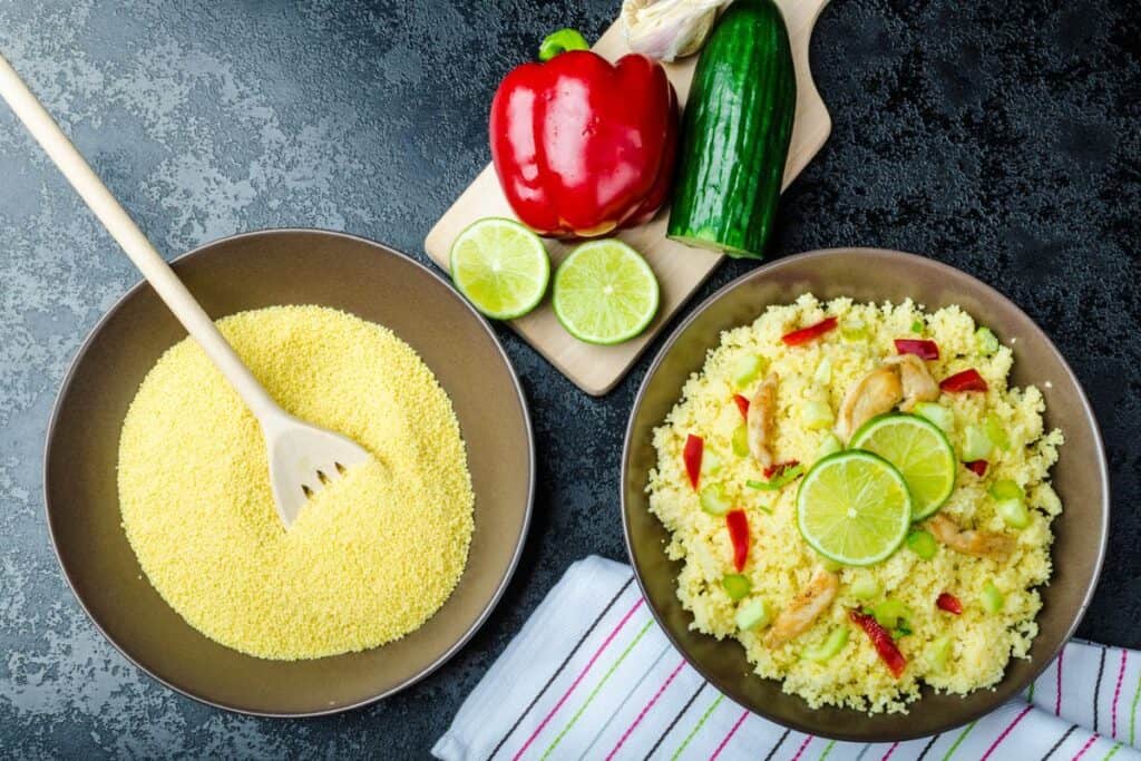 Couscous with grilled chicken meat and vegetables with fresh lime on top.