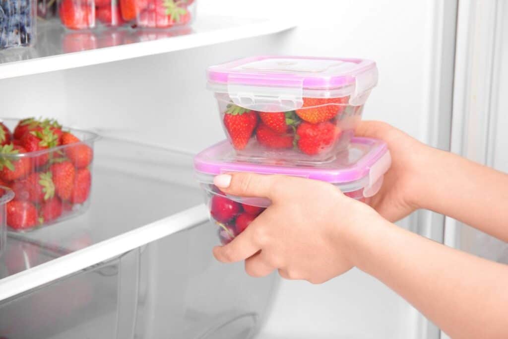 Putting of strawberries in the fridge.