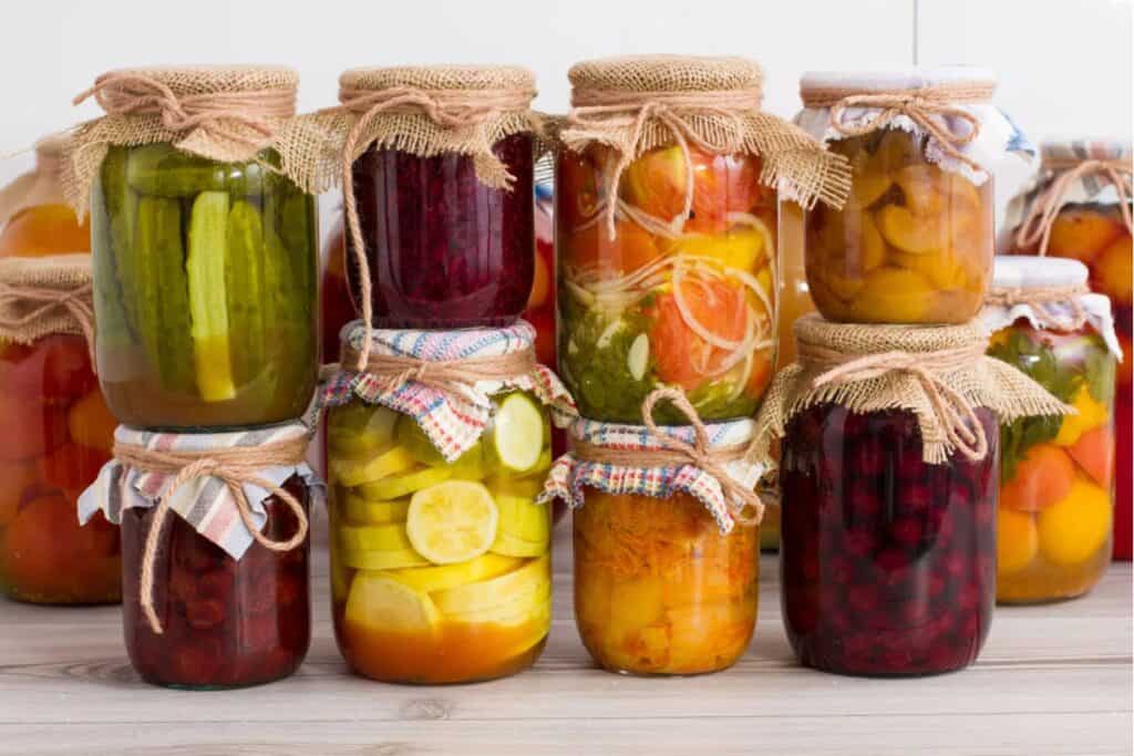 Variety of pickled fruits and veggies in jars.