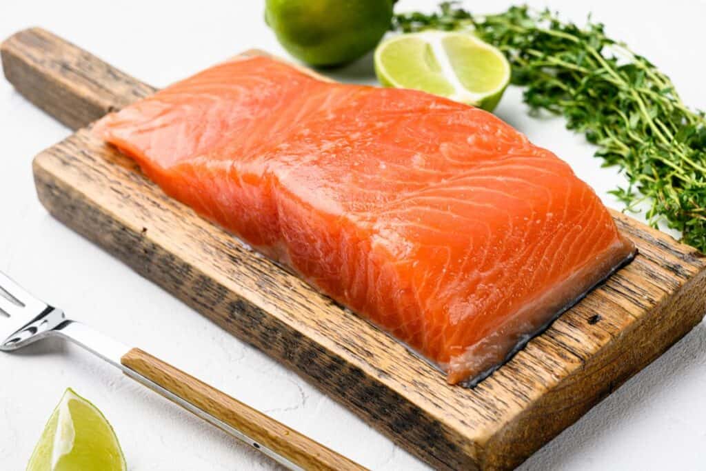 Fresh raw salmon fish fillet set, with herbs, on white stone table background