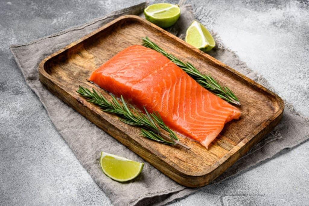 Fresh raw salmon fillet set, with herbs, on gray stone table background,