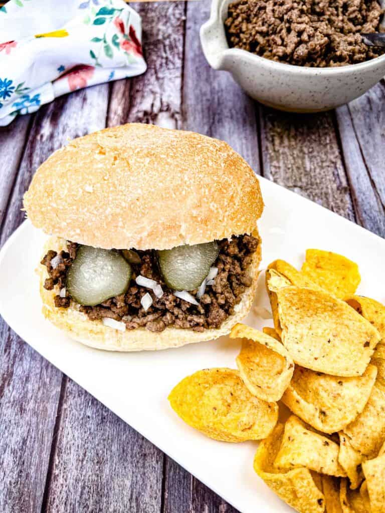 Copycat Maid-Rite Loose Meat Sandwich with chips on a white plate.