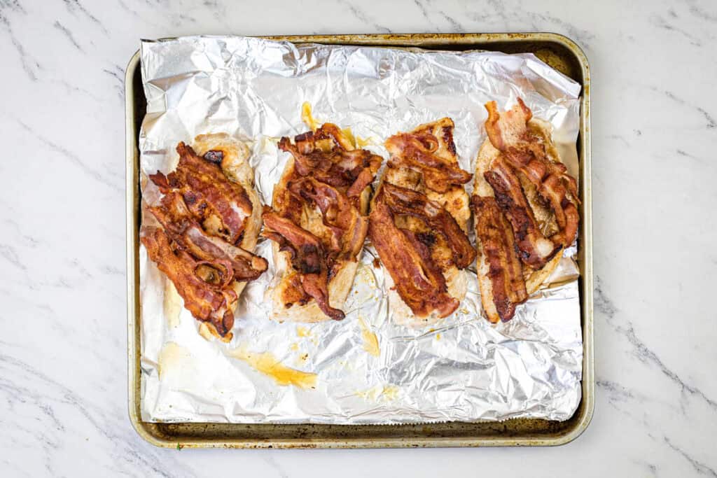 Top breasts with 2 bacon slices each.