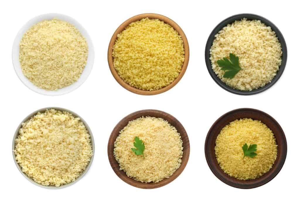 Delicious couscous in bowls on a white background, top view.