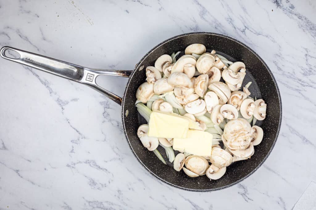Melt butter in a skillet over medium-high heat, add onions and mushrooms.