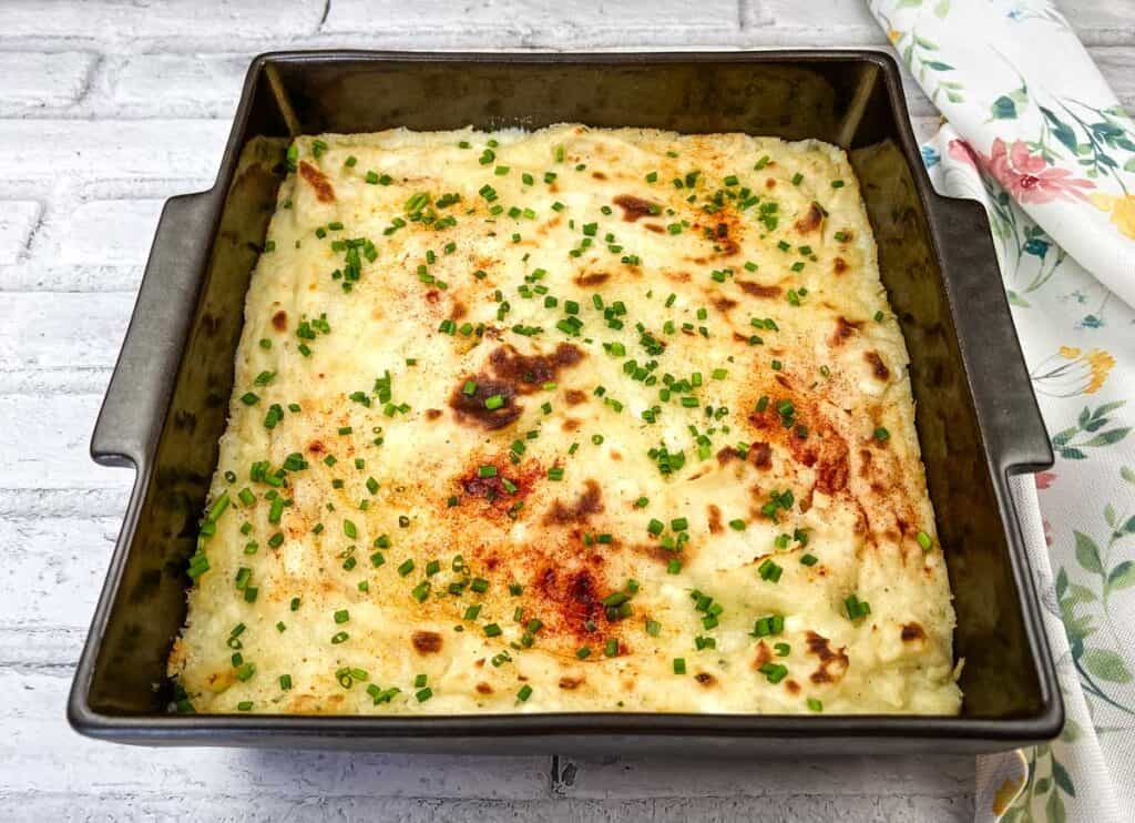 Grandma's Mashed Potato Casserole in a black baking dish.