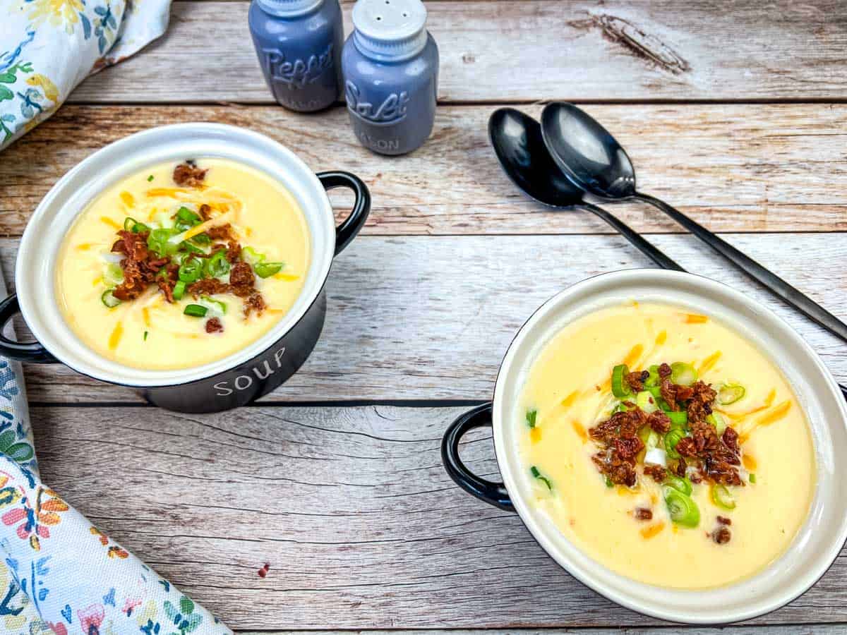 Two bowls of a Copycat Jason's Deli Irish Soup with spoons on the table.