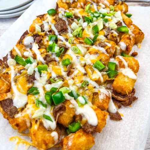 Vertical shot of Copycat Domino’s Philly Cheesesteak Loaded Tots on a white plate.