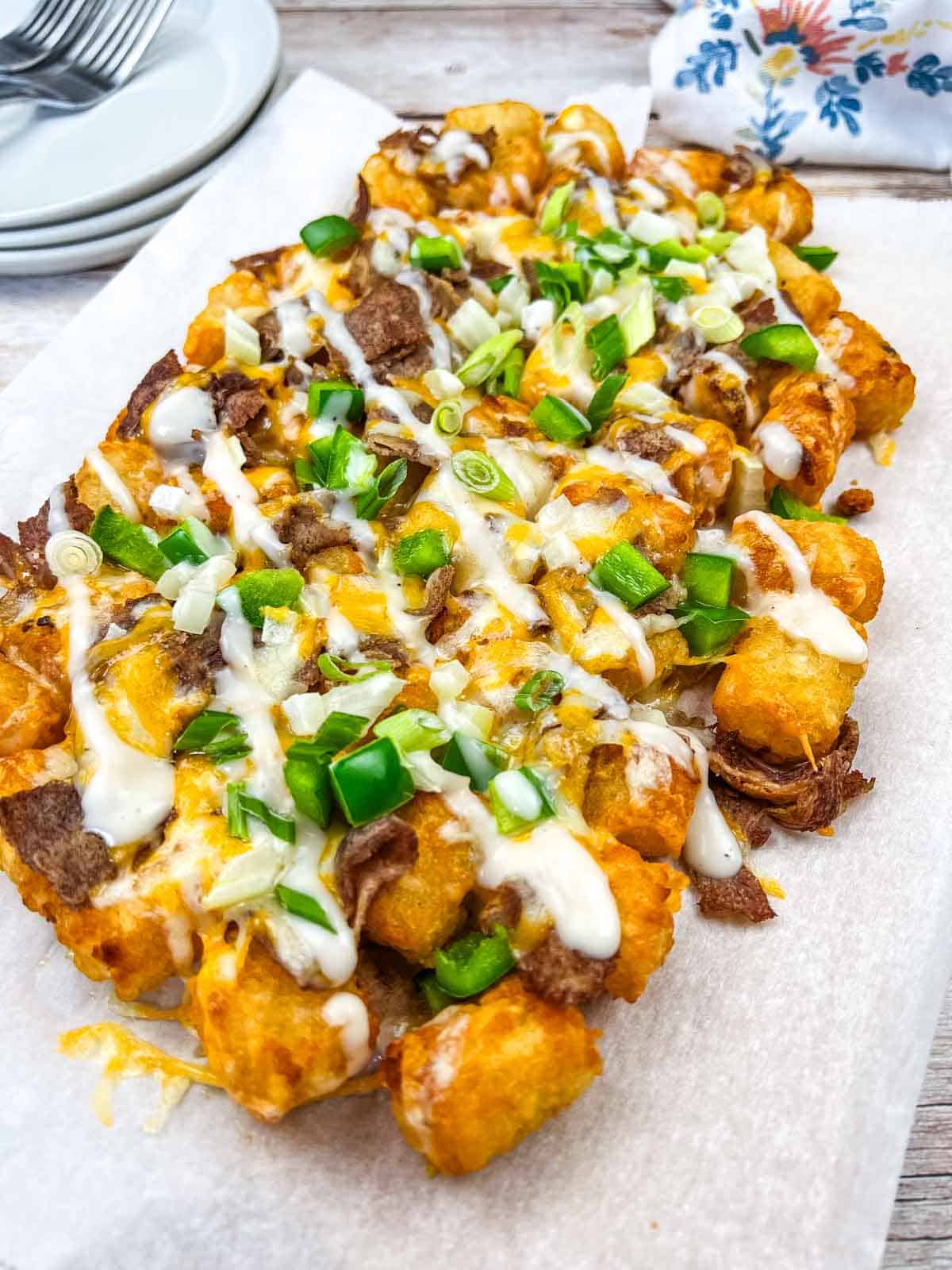 Vertical shot of Copycat Domino’s Philly Cheesesteak Loaded Tots on a white plate.