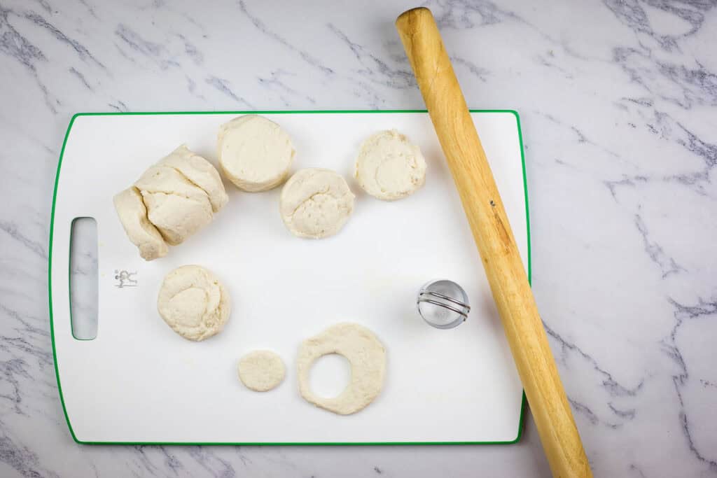 Separate biscuit dough into individual pieces and cut each biscuit in half.