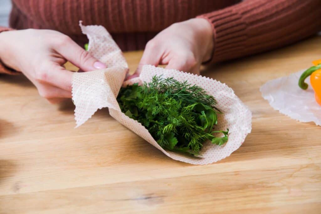 Wrapping dill in a paper tissue.