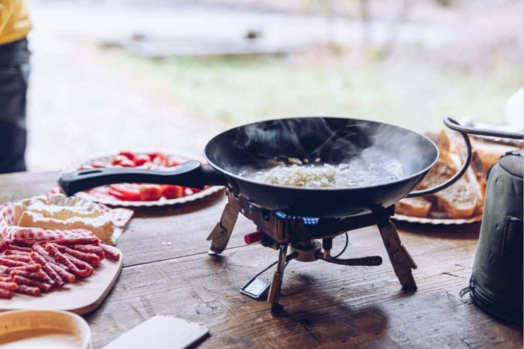 Frying scrambled eggs in campfire site.