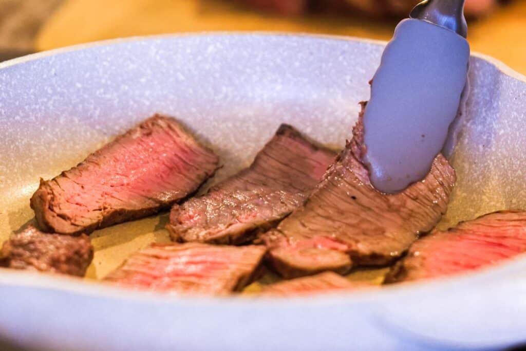 Cooking thin slices of steak.