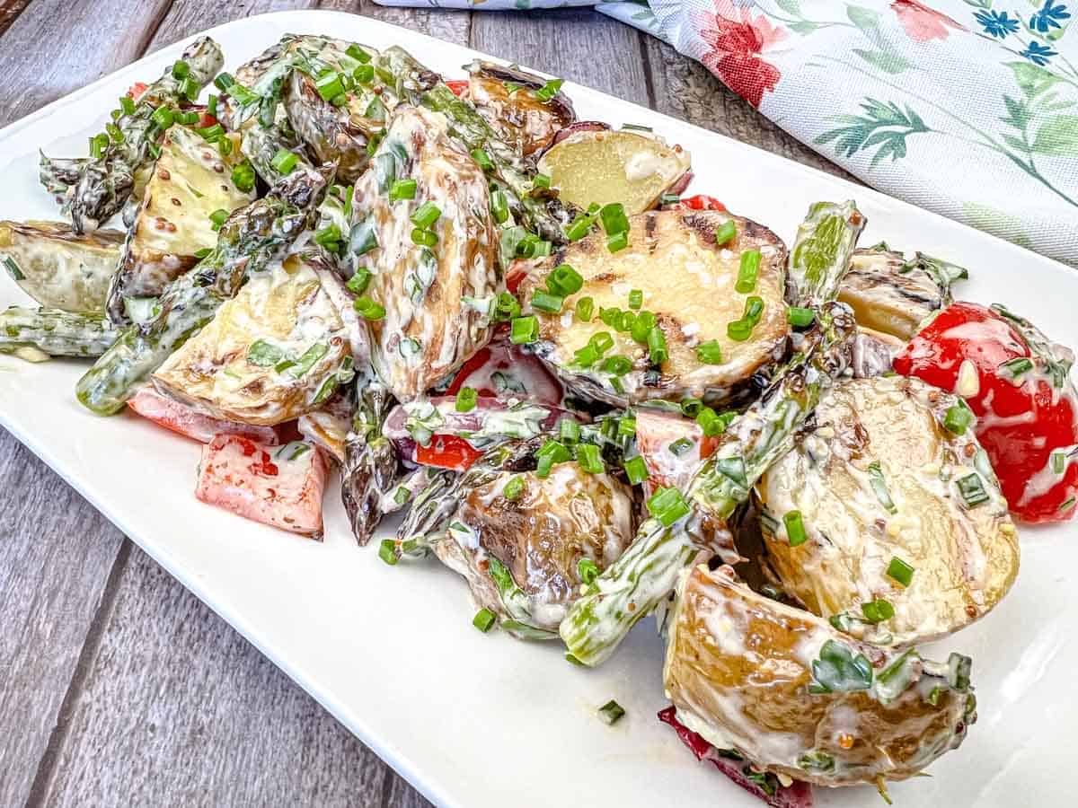 Close-up shot of Grilled Asparagus and Potato Salad on a white plate.