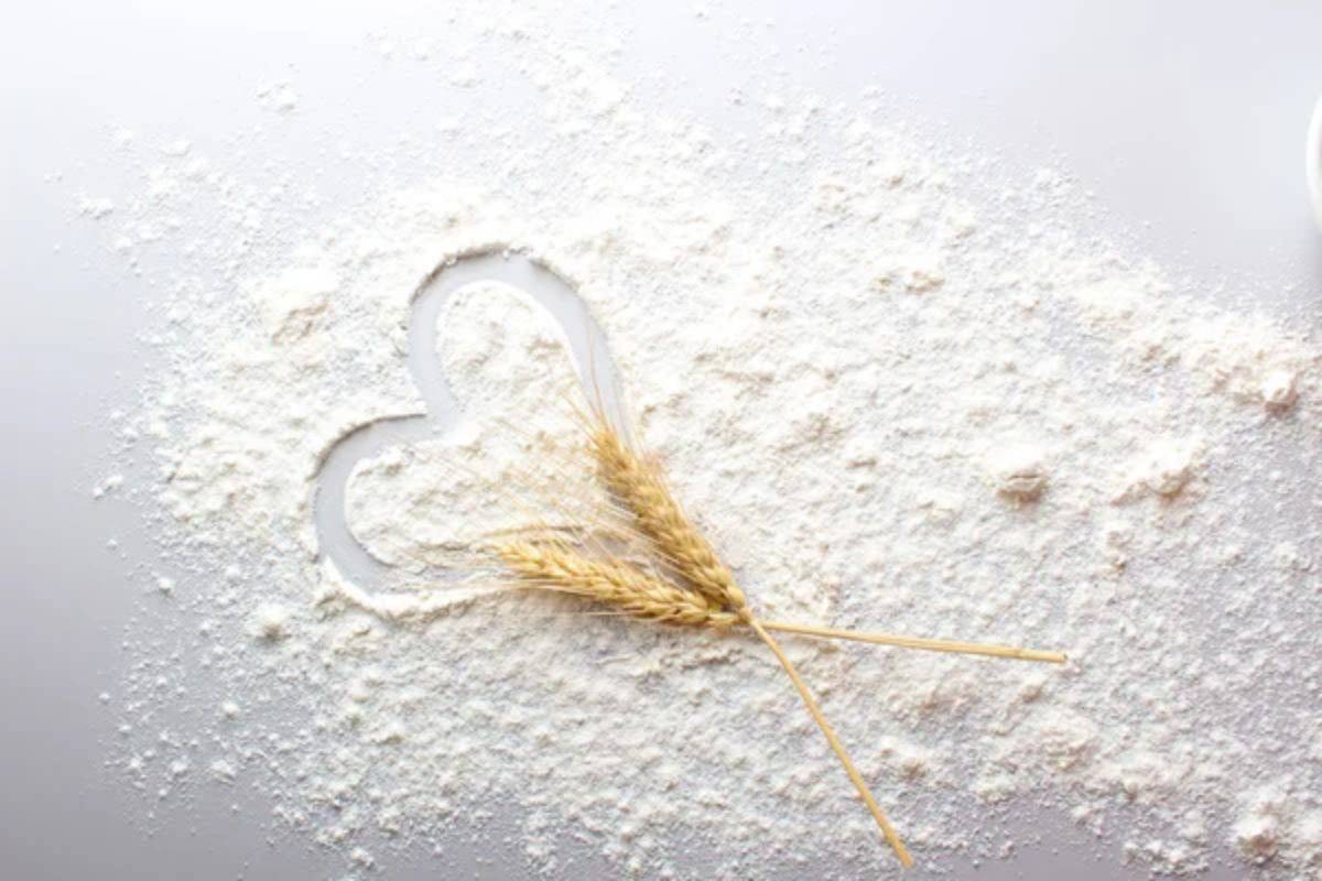 Flour in heart shape on a white table.