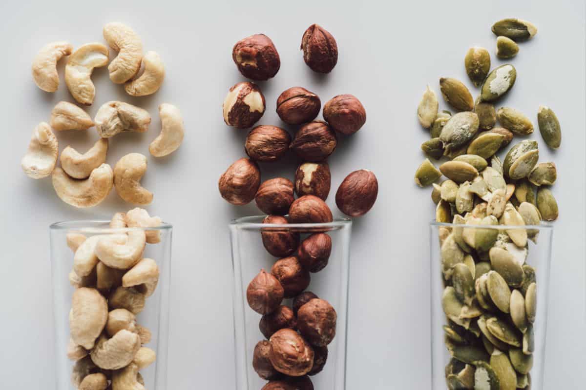 Variety of nuts and seeds on glass containers.