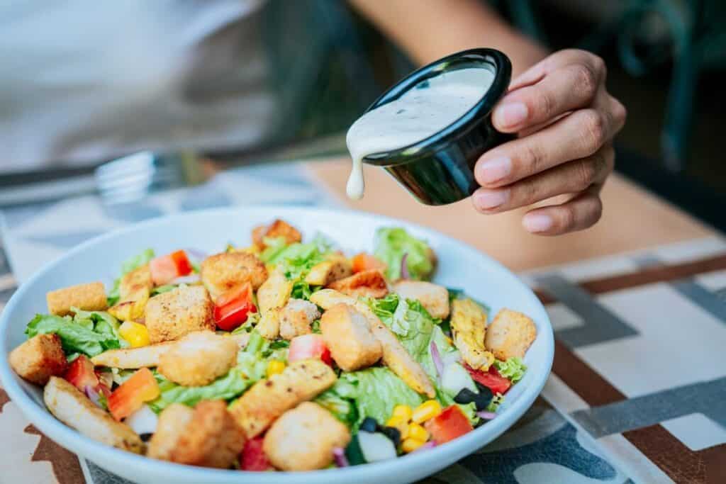 Close up of hand preparing a vegetable salad.