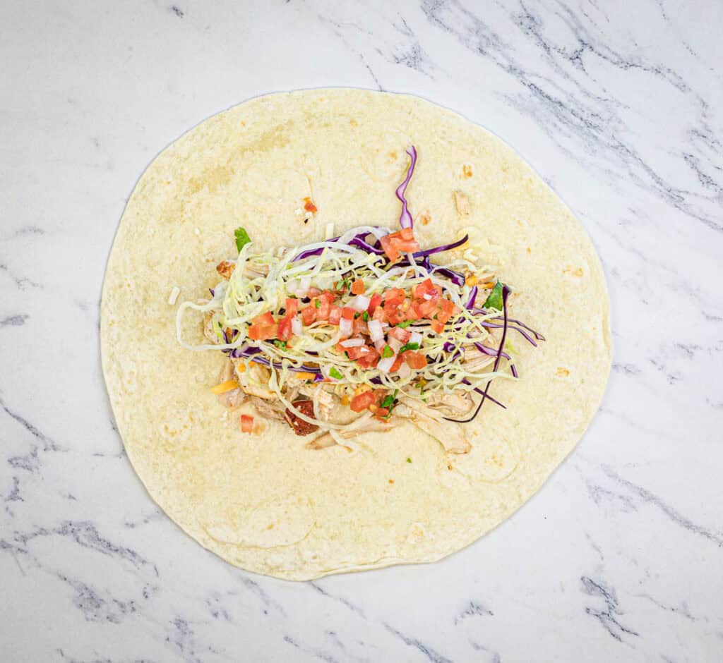 Fill tortillas with chicken, cabbage, lettuce, cheese, and pico de gallo.