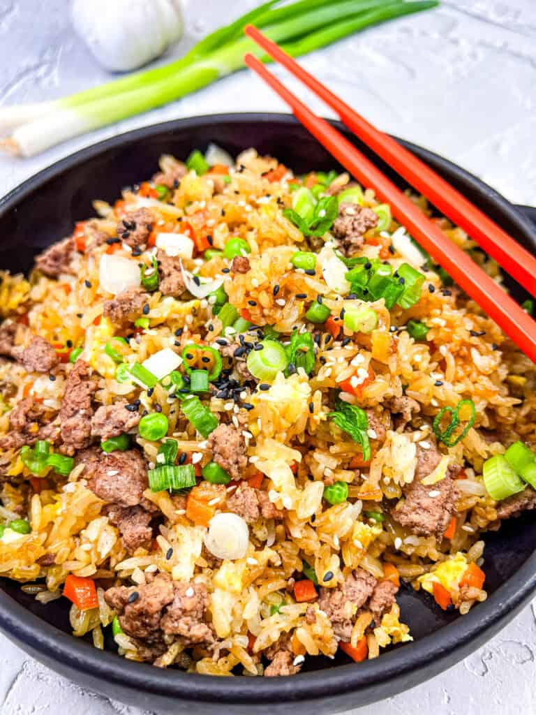 Ground Beef Fried Rice in a bowl with a pair of chopsticks.