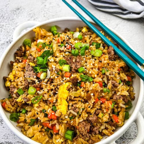 Ground Beef Fried Rice in a white bowl with a pair of chopsticks.