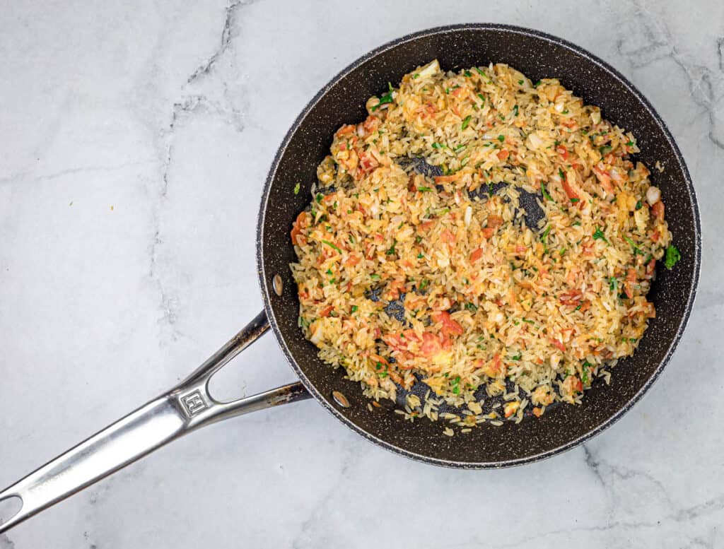 Add rinsed, drained rice to the skillet. Stir continuously to coat with oil and sauté until golden brown.