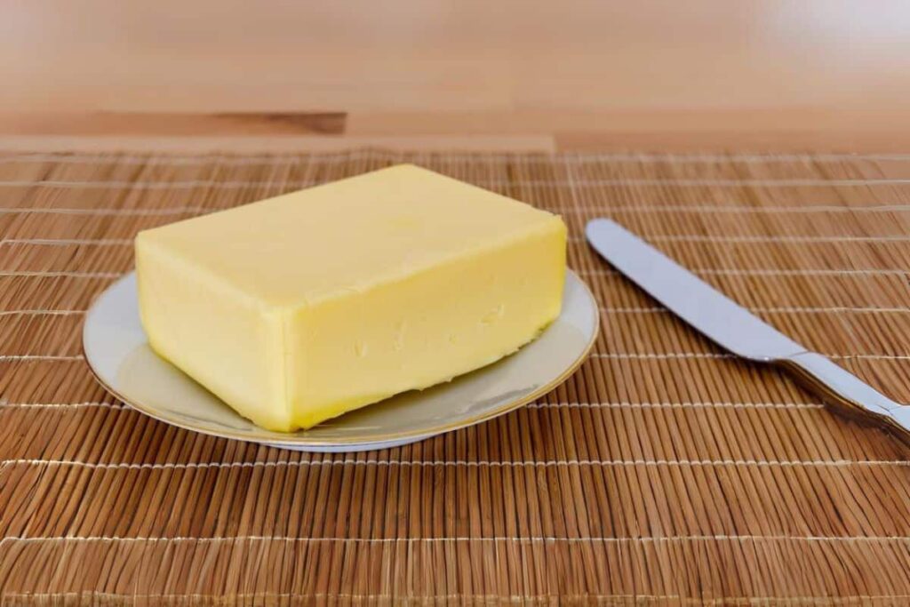 Soft butter on a plate with a knife.