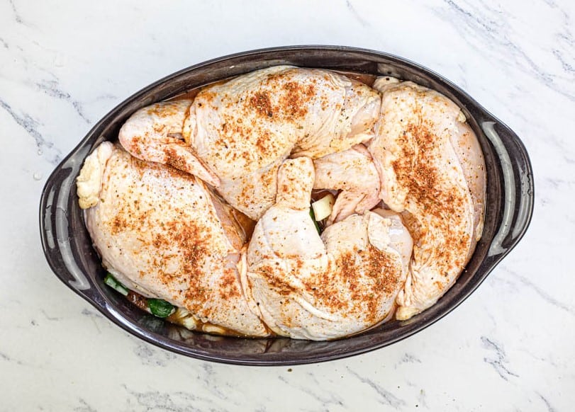 Add the seasoned chicken to the baking dish over the vegetables.