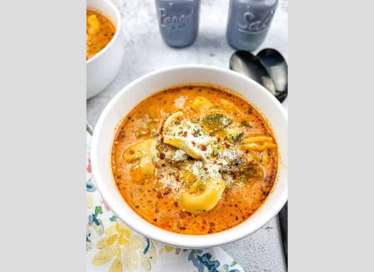 Tortellini Soup with Sausage in a white bowl.