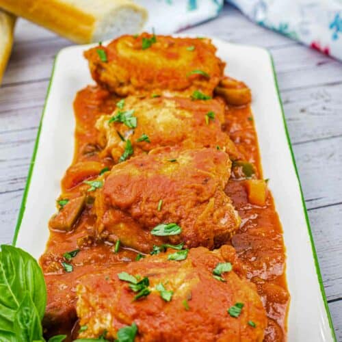 Four pieces of Chicken Cacciatore on a serving platter.