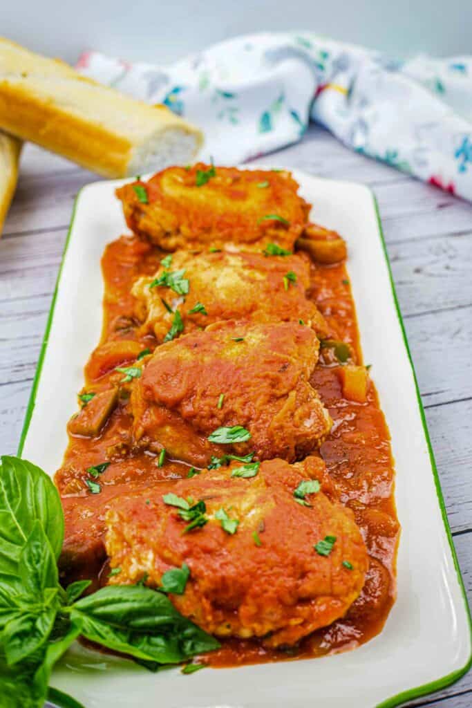 Four pieces of Chicken Cacciatore on a serving platter.