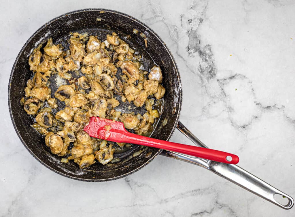 Sprinkle the flour over the onions and mushrooms.