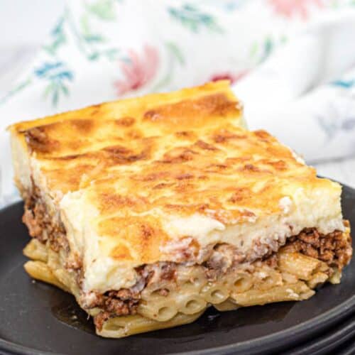 A small portion of Pastitsio on a black plate.