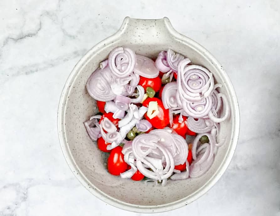 Mix the grape tomatoes, olives, capers, garlic, and shallot in a small bowl.