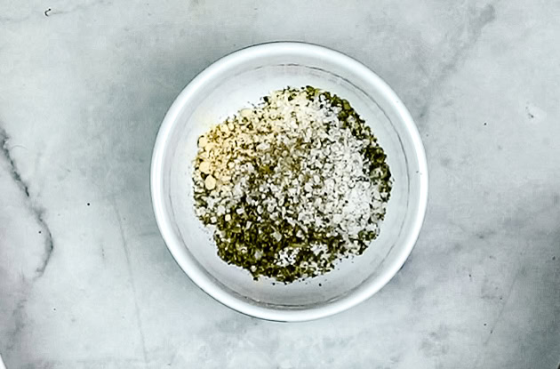 In a small bowl, combine dried oregano, garlic powder, salt, and fresh ground pepper.