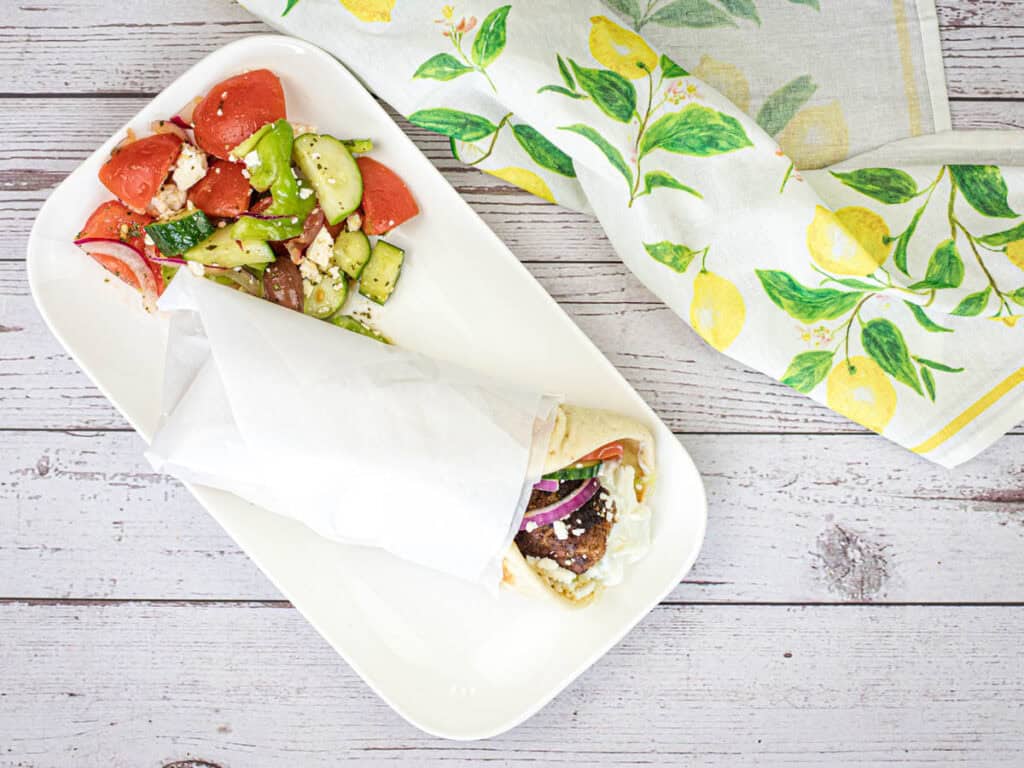 Top-down shot of Greek Meatball Pita Sandwich on a white plate.