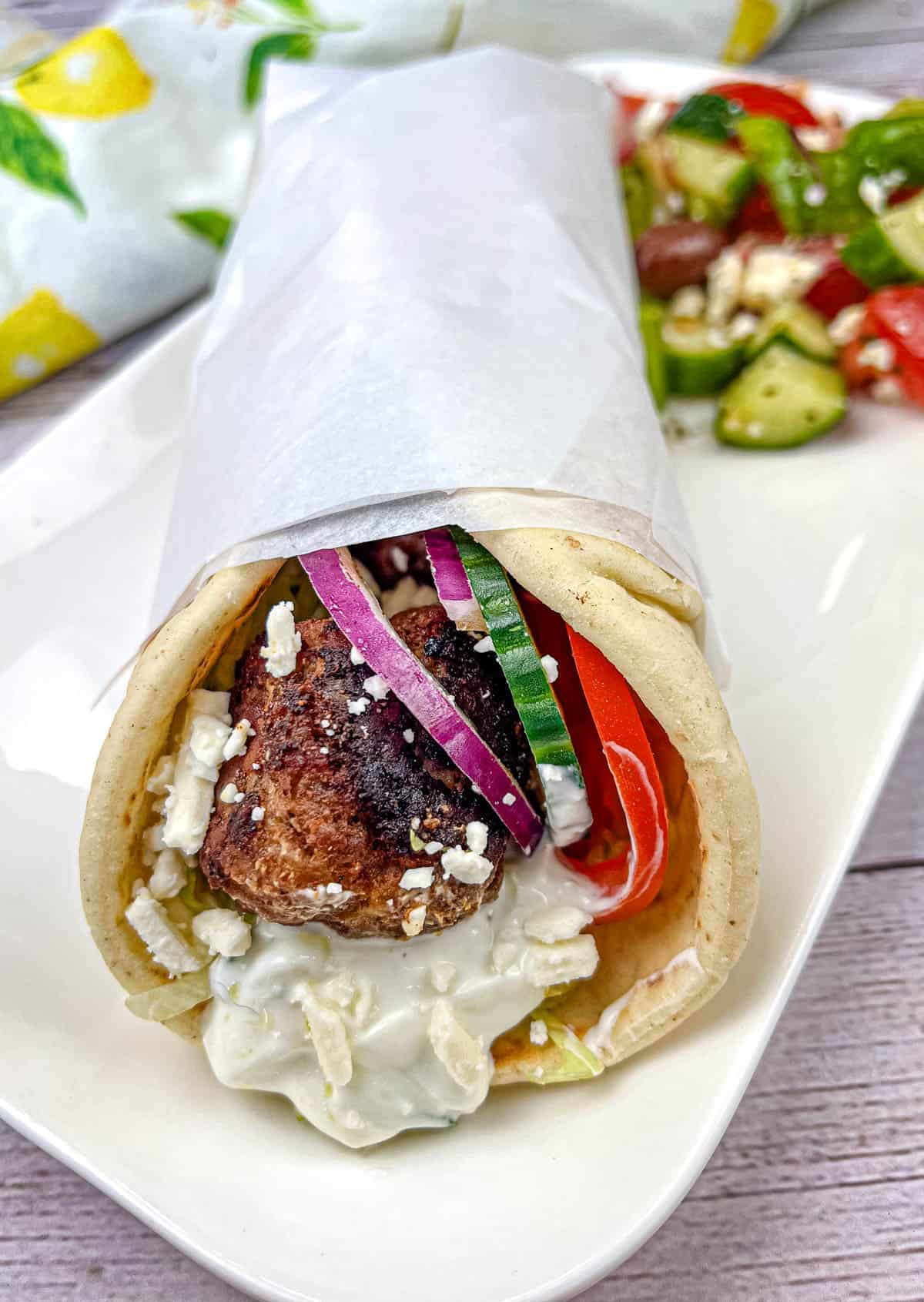 Greek Meatball Pita Sandwich on a white plate.