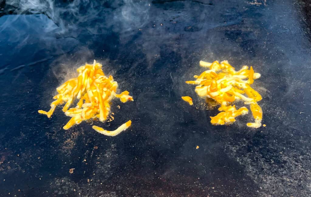 Place 1 tablespoon of shredded cheese onto the griddle.