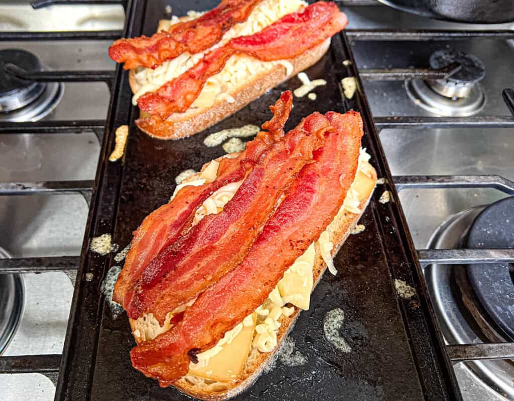 Top the bread with one slice of cheese, followed by three slices of bacon.