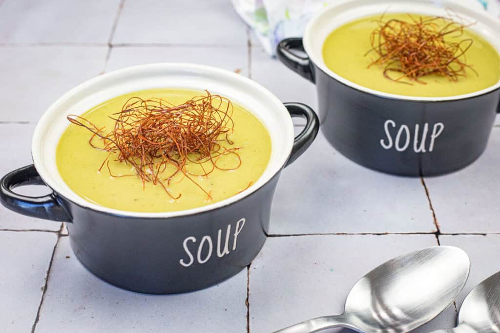 Close-up shot of two bowls of Cream of Poblano Soup.