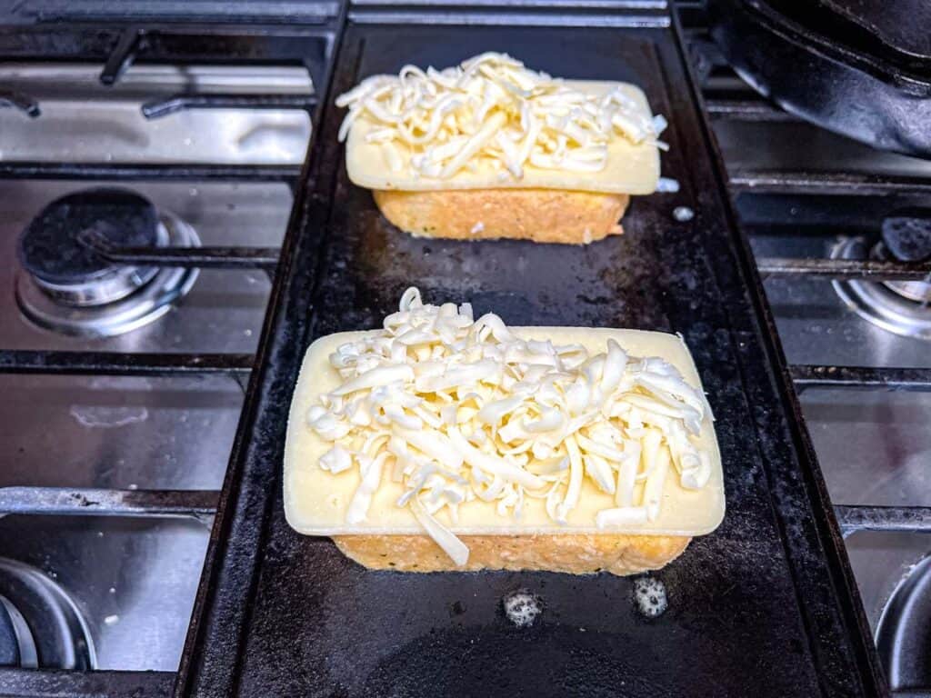 Sprinkle about ¼ cup of shredded mozzarella evenly on the sliced cheese.