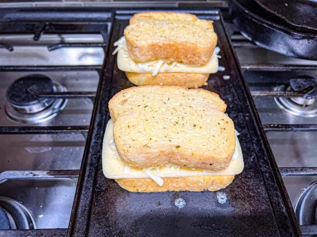 Top each sandwich with another slice of garlic bread