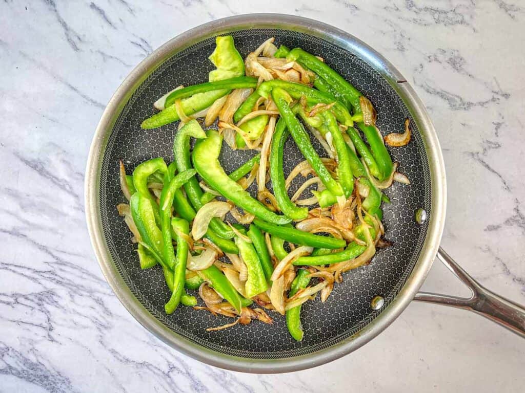 Sauté onions and mushrooms until caramelized, then add green bell pepper.