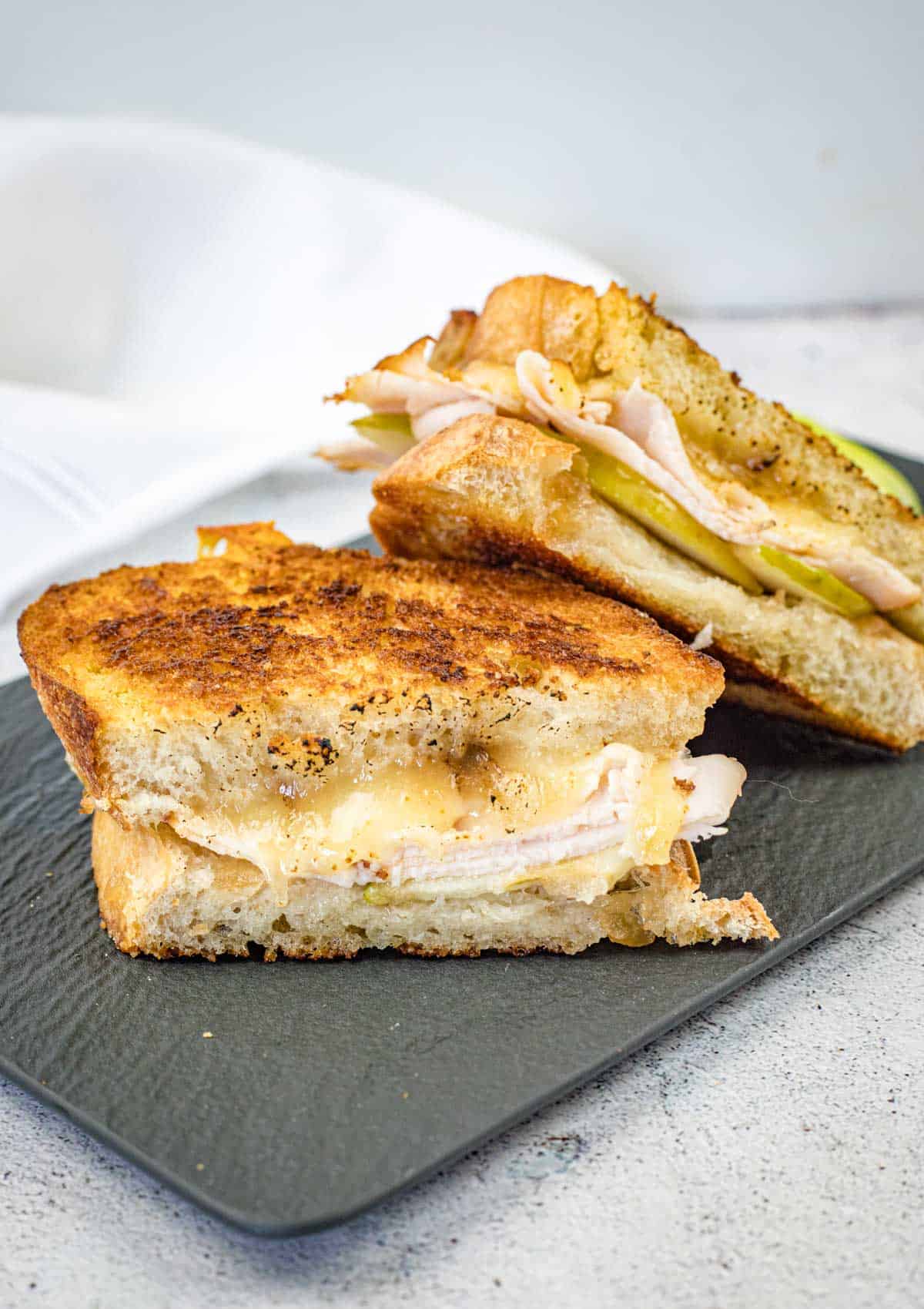 Turkey & Apple Grilled Cheese on a slate plate.