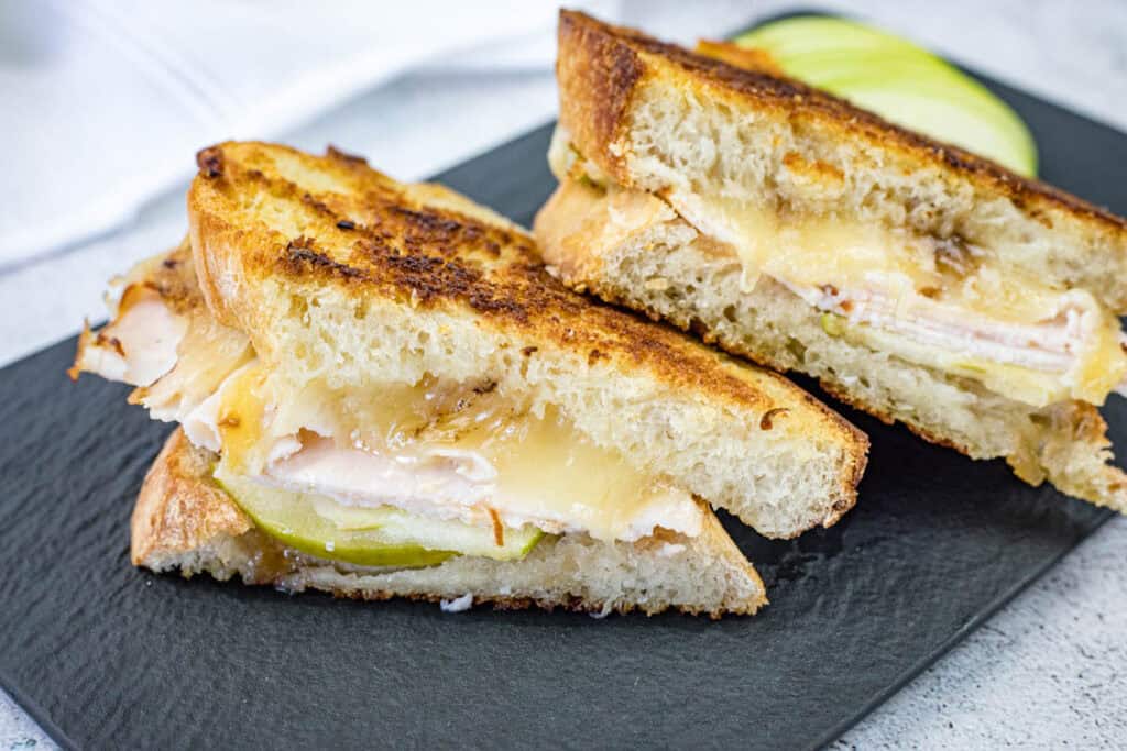 Turkey & Apple Grilled Cheese on a black slate plate.