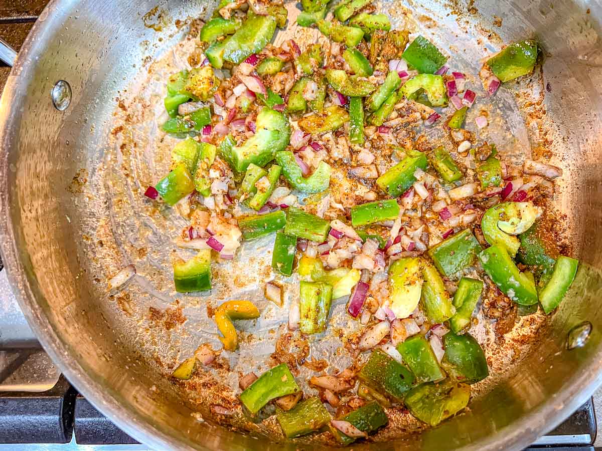 Add the remaining butter to the skillet, then add the green bell pepper, red onion, and garlic.