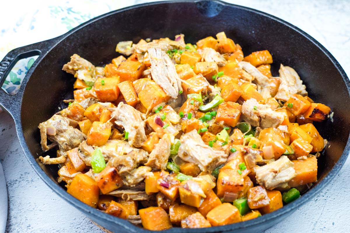 Sweet Potato Hash with Pulled Pork & Chipotle Butter on a skillet.