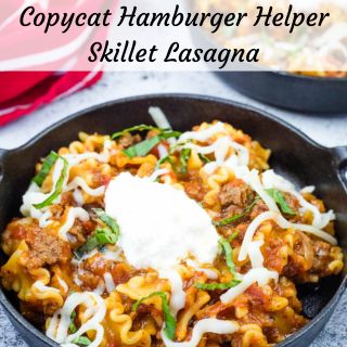 A skillet lasagna topped with ricotta, shredded cheese, and chopped basil.